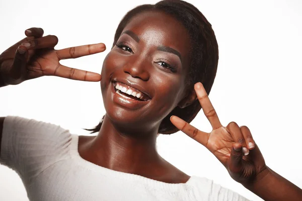 Africano americano mulher sorrindo olhando para a câmera mostrando os dedos fazendo sinal de vitória sobre fundo branco — Fotografia de Stock