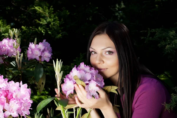 Donna sorridente all'aperto con alcuni fiori — Foto Stock