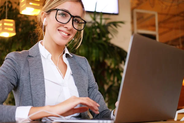 Mujer de negocios trabajando en el ordenador portátil en la cafetería. Joven mujer de negocios utiliza el ordenador portátil en la cafetería. Estilo de vida y concepto de negocio . — Foto de Stock