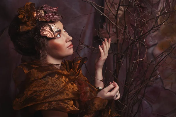 Concepto de belleza y arte: Mujer joven con maquillaje brillante con ramas secas —  Fotos de Stock