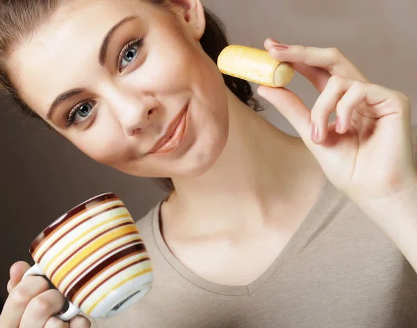 Lebensstil, Menschen und Ernährungskonzept: junge Frau mit Kaffee und Keksen — Stockfoto