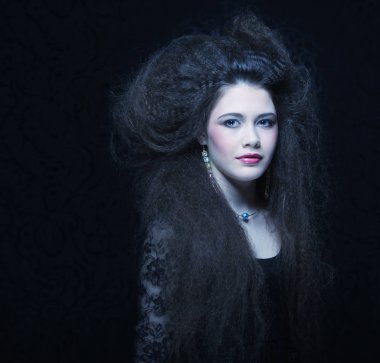 Güzel genç kadın kıvırcık saçlı ve akşam makyaj. Takı ve güzellik kavramı. Moda sanat fotoğraf.