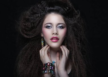 Güzel genç kadın kıvırcık saçlı ve akşam makyaj. Takı ve güzellik kavramı. Moda sanat fotoğrafı. yakın çekim