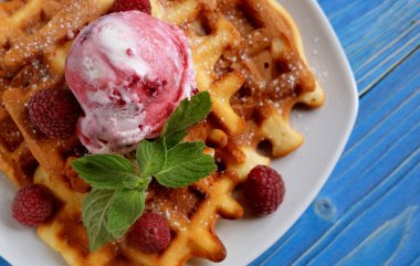 Waffle ahududu Ice cream ve nane ile dekore edilmiş mavi ahşap arka plan üzerinde taze frambuaz