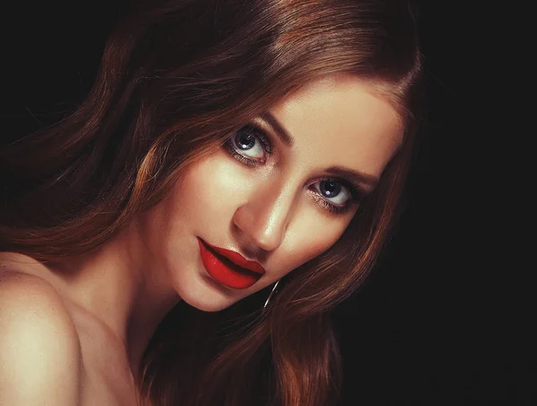 Chica rubia de la moda con el pelo rizado largo y brillante. Labios rojos y maquillaje brillante. Sobre fondo negro . — Foto de Stock