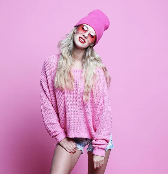 Стильный модный портрет трезвенной случайной молодой женщины в розовом пуловере и шляпе, позирующей на розовом фоне . — стоковое фото