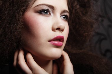 Güzel genç kadın kıvırcık saçlı ve akşam makyaj. Takı ve güzellik kavramı. Moda sanat fotoğraf.