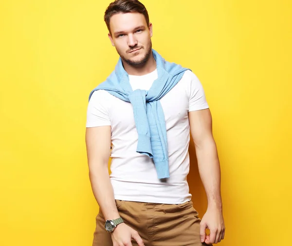 Portrait of a handsome young man, fashion model. Posing over yellow wall. Lifestyle and fashion concept. — Stock Photo, Image