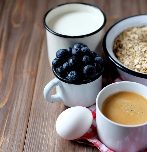 Ein gesundes Frühstück - Haferbrei, gekochtes Ei, Milch, frische Beeren und Kaffee. Ein toller Start in einen neuen Tag. Ansicht von oben. — Stockfoto