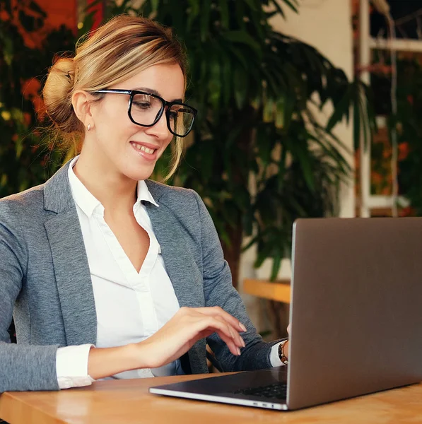 Emberek és üzleti koncepció: A fiatal, vonzó üzleti nő ül egy kávézóban, a laptop — Stock Fotó