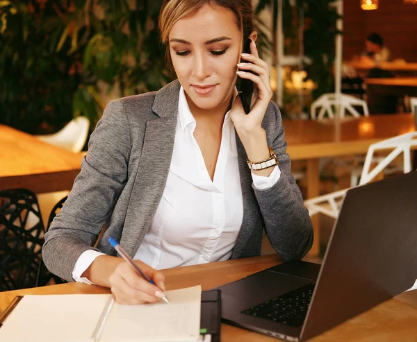 Mujer feliz utilizando el chat con el móvil y el ordenador portátil de uso — Foto de Stock