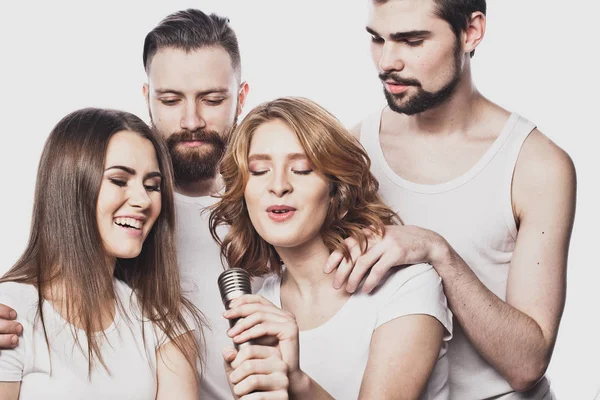 Group of friends playing karaoke over white background. Concept about friendship and people. — Stock Photo, Image