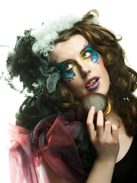 Jonge vrouw met creatieve make-up met taart. — Stockfoto