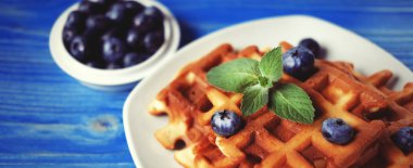 Ev yapımı Belçika waffle taze yaban mersini ve ahududu ahşap arka plan üzerinde. Üstten Görünüm.