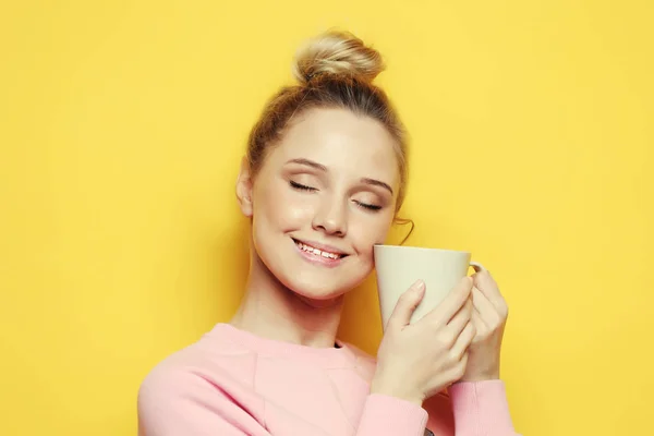 Estilo de vida, comida e conceito de pessoas: jovem mulher bonita beber café sobre fundo amarelo — Fotografia de Stock