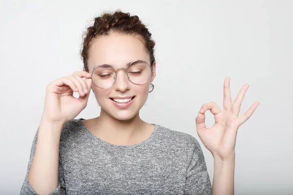 Mujer positiva estudiante usa suéter gris, gafas redondas . — Foto de Stock