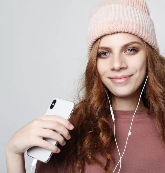 Style de vie et concept de personnes : jeune femme dans un casque avec smartphone à l'écoute de la musique. — Photo