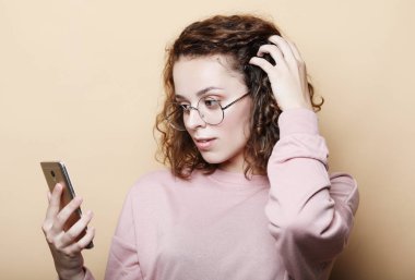 yaşam tarzı, duygusal ve insanlar kavramı: genç güzel kıvırcık kadın ile smartphone