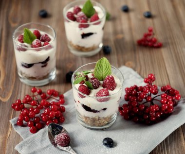 Cam, ahşap arka plan üzerinde sağlıklı kahvaltı - taze meyveler ve müsli yoğurtla servis