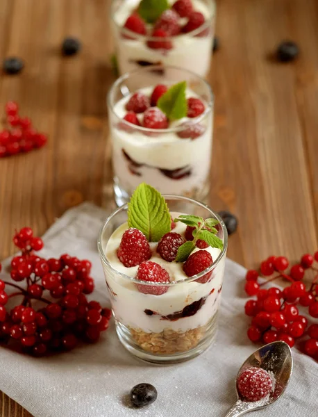 Desayuno saludable yogur con bayas frescas y muesli servido en frasco de vidrio, sobre fondo de madera, de cerca —  Fotos de Stock