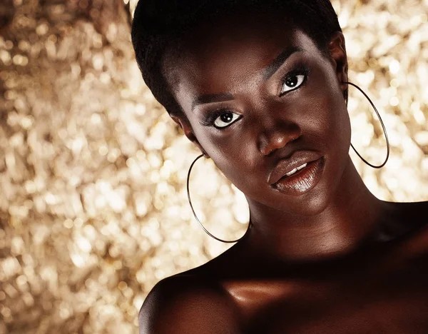 Impressionante Retrato de uma mulher negra afro-americana sobre fundo dourado — Fotografia de Stock