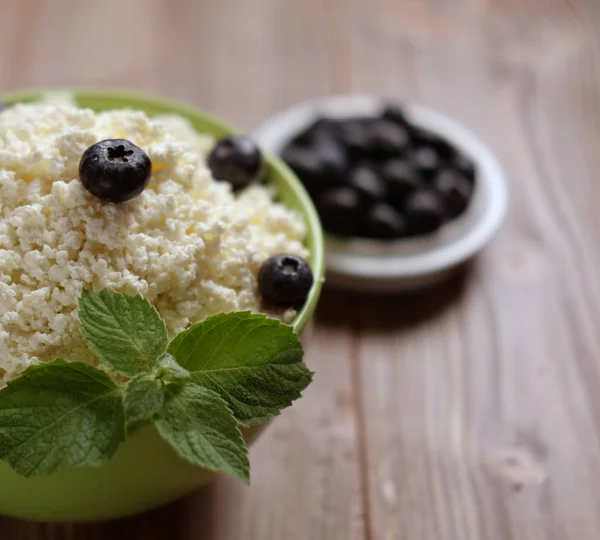 Cottage cheese and blueberry in a bowl on a table. Good breakfast — Stock Photo, Image