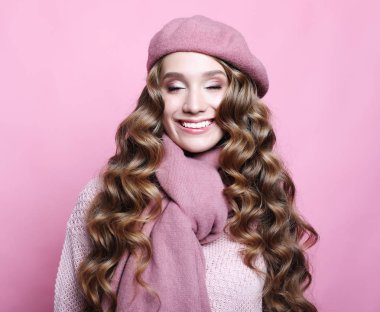 Uzun dalgalı saçlı, pembe bereli ve eşarplı güzel bir bayan model.