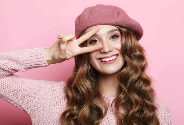 Schöne junge weibliche Modell mit langen welligen Haaren trägt rosa Baskenmütze und Schal — Stockfoto