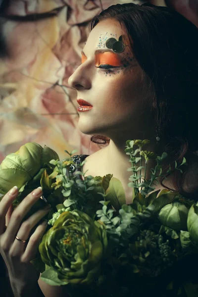 Concetto di bellezza e arte: Giovane donna con trucco luminoso con rami secchi — Foto Stock