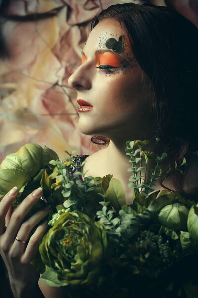 Close up portrait redhair woman with bright creative make up holding dry flowers, studio shoot