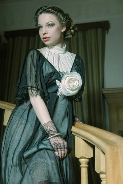 Mujer en vestido elegante posando en escaleras — Foto de Stock