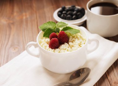 Berry ve nane, yaban mersini ve ahşap masa kahve Rus süzme peynir.