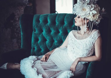 Güzel gelin bir sandalyeye oturur. Lüks Sarayı.