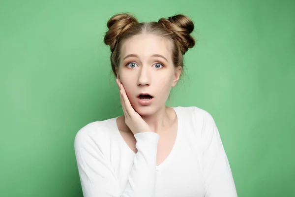 Estilo de vida y el concepto de la gente: Mujer joven sorprendida gritando sobre fondo verde. Mirando la cámara . —  Fotos de Stock