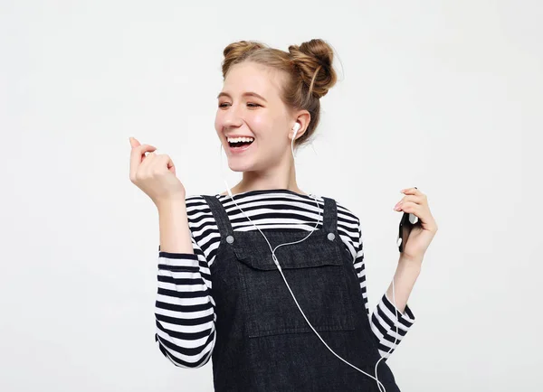 Hermosa mujer en auriculares escuchando música sobre fondo blanco — Foto de Stock