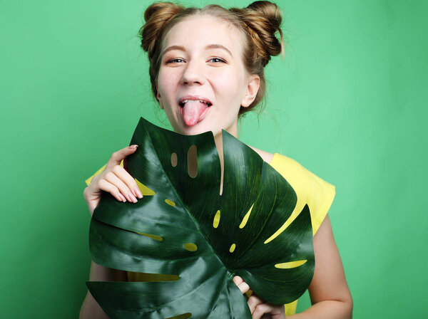 funny girl showing her tongue while posing against studio background.