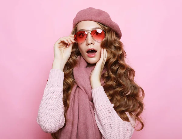 Красивая молодая модель с длинными волнистыми волосами в розовом берете, шарфе и очках — стоковое фото