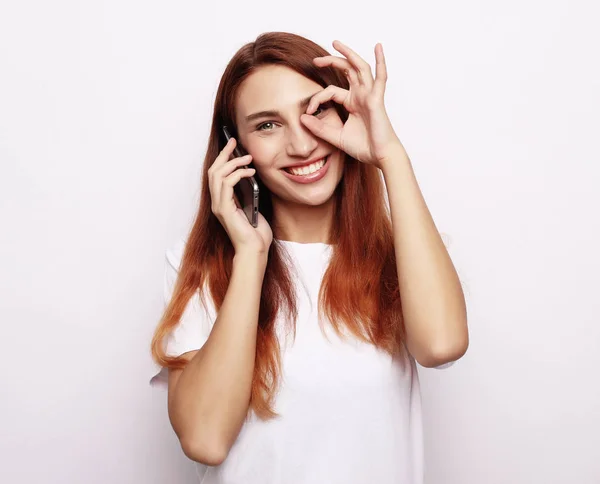 Primer plano retrato de la hermosa mujer alegre sonriendo, demostrando dientes blancos, mirando a la cámara a través de los dedos en buen gesto . — Foto de Stock