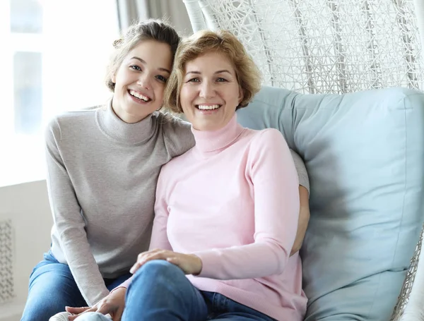 Beautiful senior mom and her adult daughter are hugging, looking at camera and smiling. — Stock Photo, Image