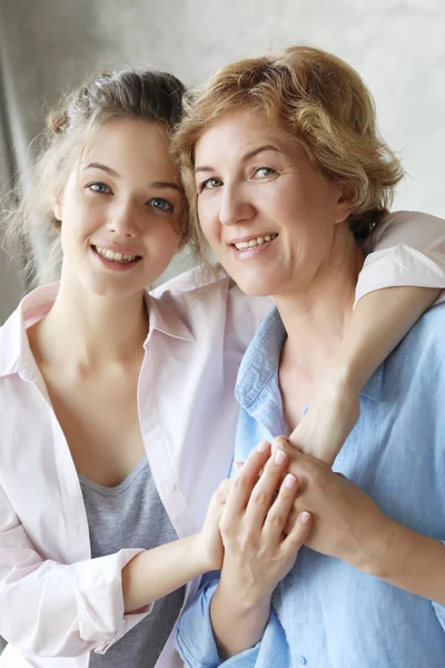 Estilo de vida, familia y gente concepto: Feliz joven mujer y su madre en casa —  Fotos de Stock