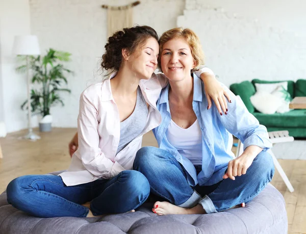 Livsstil, familj och människor koncept: Glad ung kvinna och hennes mamma hemma, — Stockfoto