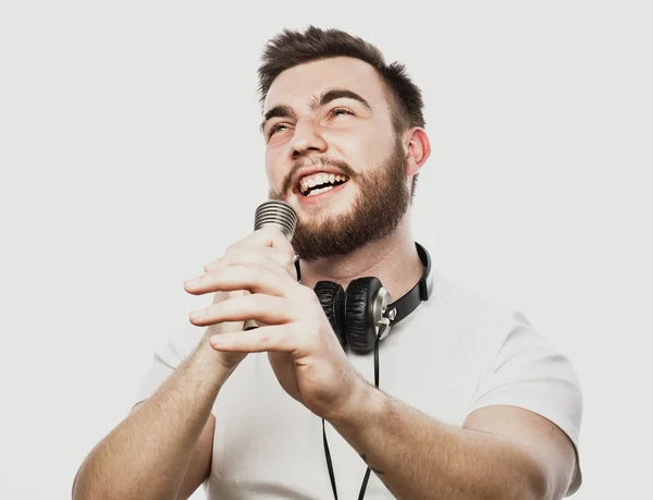 Νέοι γενειοφόρος άνδρας με ακουστικά και μικρόφωνο πάνω από το λευκό φόντο — Φωτογραφία Αρχείου
