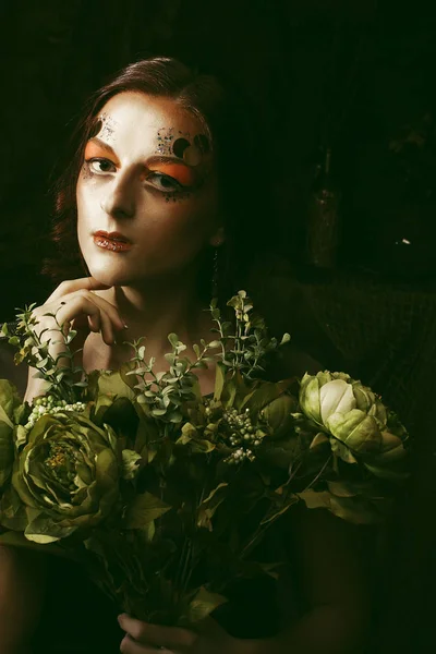 Bliska portret redhair kobieta z jasny kreatywnych makijaż trzyma suchych kwiatów — Zdjęcie stockowe