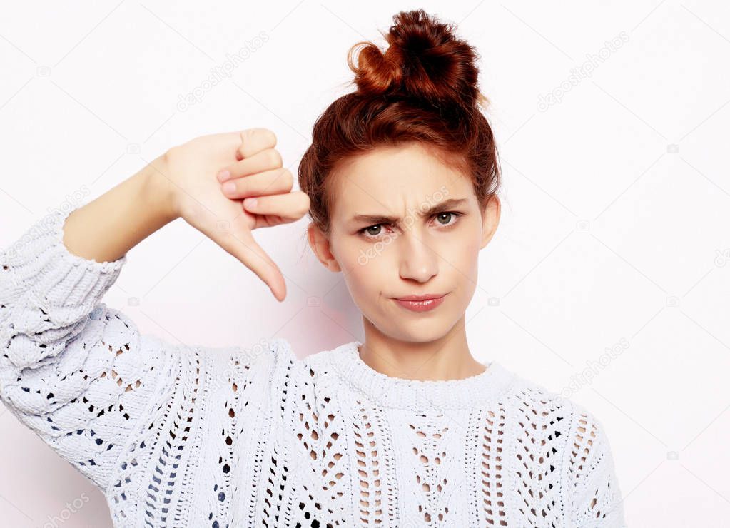lifestyle, emotion and people concept: Thumb down sign, young woman with unhappy negative expression