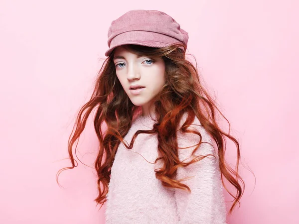 Bild eines glücklichen Teenie-Mädchens, das isoliert auf rosa Hintergrund steht, in rosa Hut und Pullover. Lifestyle- und Modekonzept. — Stockfoto