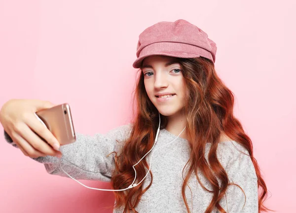 Wesoła dziewczynka z kręconymi włosami l biorąc selfie na białym tle różowy zbliżenie — Zdjęcie stockowe