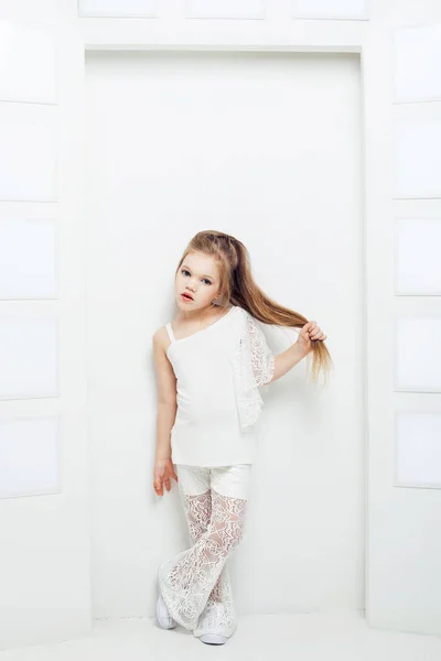 Cute little blond girl wearing white casual clothes on a white background. Fashion style. — Stock Photo, Image