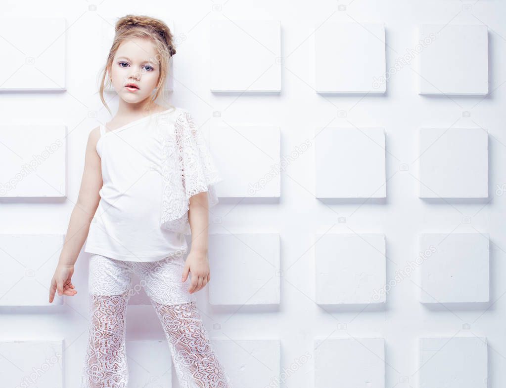 Cute little blond girl wearing white casual clothes on a white background. Fashion style.