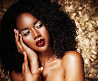 afro saçlı genç zarif Afrikalı-Amerikalı kadın. Glamour makyaj. Altın arka plan.