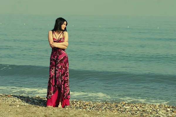 Mujer en vestido rosa en la playa de mar — Foto de Stock